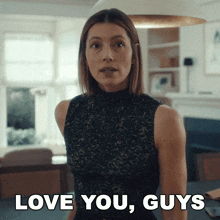 a woman says " love you guys " while standing in a living room