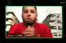 a man in a red shirt is talking on a video call on a computer screen .