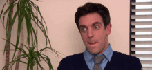 a man in a blue shirt and tie is making a funny face .