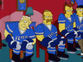 a group of flyers hockey players are sitting in a row