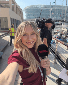 a woman holding a microphone that says ' formula one ' on it