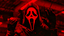 a person wearing a scream mask and holding a knife
