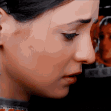 a close up of a woman 's face with a picture behind her