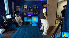 a man is standing in a room with a blue couch and a blue toilet