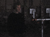 a man wearing headphones stands in front of a computer monitor