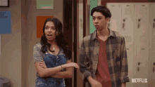 a man and a woman are standing next to each other in a hallway with netflix written on the bottom