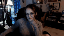 a woman wearing glasses is sitting in a chair