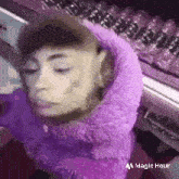 a person is wearing a purple sweater and a purple scarf around their head .