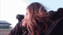 a woman 's hair is blowing in the wind behind another woman