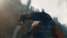 a man in a superhero costume is flying through the air while holding a sword .