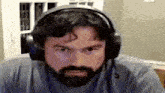 a man with a beard is wearing headphones and a microphone .