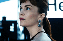 a close up of a woman 's face with a sign in the background that says ' hc '