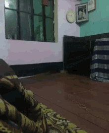 a room with a clock on the wall and a picture on the wall above it
