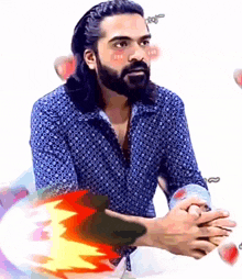 a man with long hair and a beard is wearing a blue shirt with polka dots