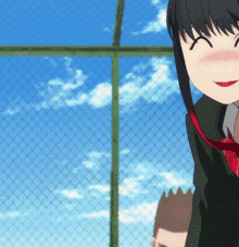 a girl with a red tie is standing next to a fence