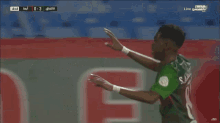 a soccer player wearing a green jersey with the number 6 on the back