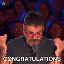 a man wearing red sunglasses is giving a thumbs up and the word congratulations is written below him