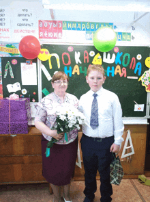 a boy and a woman standing in front of a blackboard that says poka