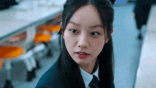 a close up of a woman in a school uniform and tie .