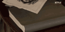 a book titled glory sits on a table with a netflix logo behind it