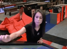 a woman in a black shirt is standing in front of a directo sign ..