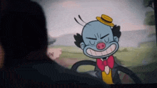 a man is looking at a cartoon of a clown wearing a bow tie and hat .