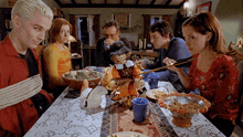 a group of people are sitting at a table with a stuffed pilgrim on it