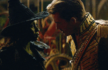 a man and a woman are looking at each other and the woman is wearing a witch costume