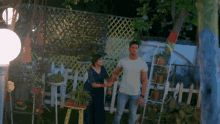 a man and woman are holding hands in a garden