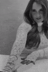 a black and white photo of a woman in a white lace top and gloves