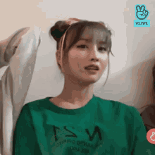 a woman wearing a green t-shirt that says tsw