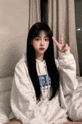 a girl wearing a white hoodie that says brooklyn on it