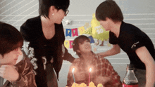 a group of people are celebrating a birthday with a cake and a balloon that says happy 20th birthday