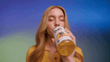 a woman is drinking from a bottle that says bai on it