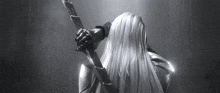 a black and white photo of a woman holding a sword