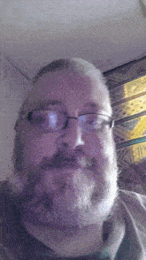 a man with a beard wearing glasses and a black shirt