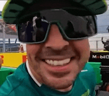 a close up of a man wearing sunglasses and a green shirt .