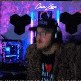 a man wearing headphones and a fur coat is standing in front of a neon sign that says " clean zone "