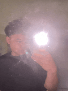 a young man is taking a picture of himself in a mirror .
