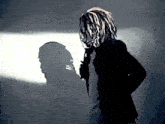 a man with dreadlocks is holding a microphone in front of his face