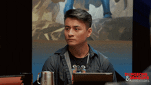 a man sitting in front of a screen that says dungeons & dragons on it