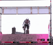 a man is riding a bike under a sign that says lap 6