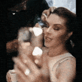 a woman is getting her makeup applied by a man