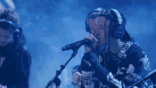 a man wearing headphones is singing into a microphone with a shirt that says down video