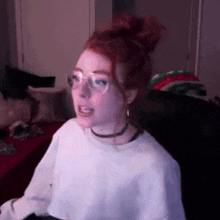 a girl with red hair is wearing glasses and a choker .