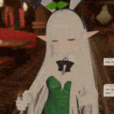 a girl with long white hair is wearing a green dress and a bunny headband
