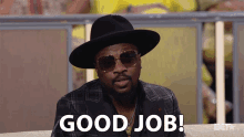 a man wearing a hat and sunglasses is saying good job