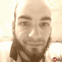 a man with a beard is smiling in a gif