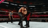 two wrestlers are wrestling in a ring with a referee in the background and the word kane on the screen