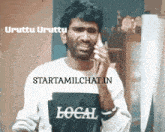 a man wearing a shirt that says local talking on a cell phone